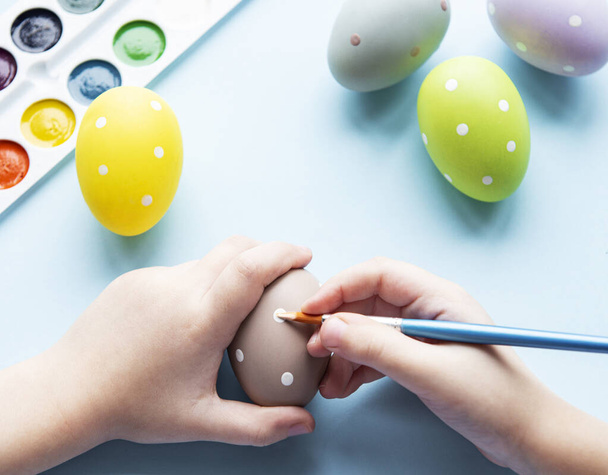 Boldog húsvéti fogalmat. Kislány, aki húsvéti tojásokat fest. Húsvétra készülök. Egy húsvéti tojásos lány kezei. közelkép - Fotó, kép