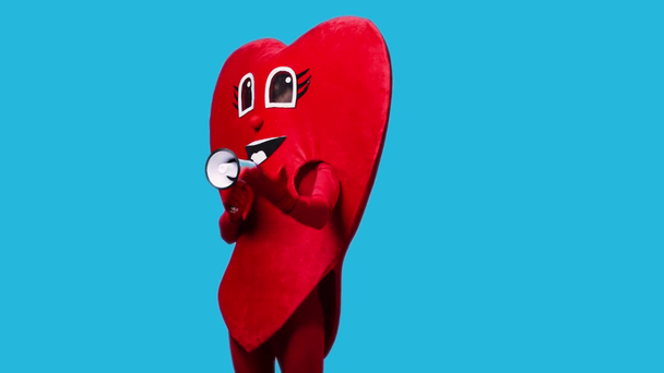 persoon in hart kostuum houden megafoon geïsoleerd op blauw - Video