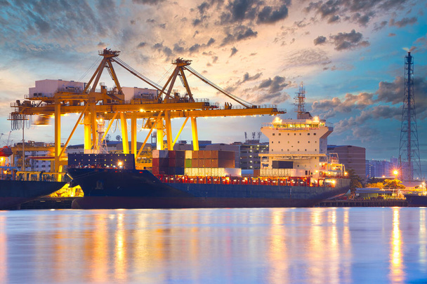 Предпосылки для кранов и промышленных грузовых судов в порту в сумерках
. - Фото, изображение