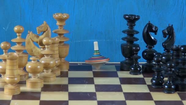 Colorful wooden whirligig  on chessboard with chessmen - Footage, Video
