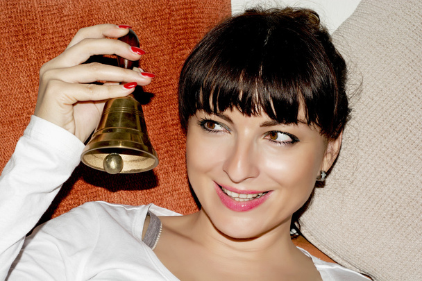 jeune brunette souriante sonnant la clochette de Noël - Fotografie, Obrázek