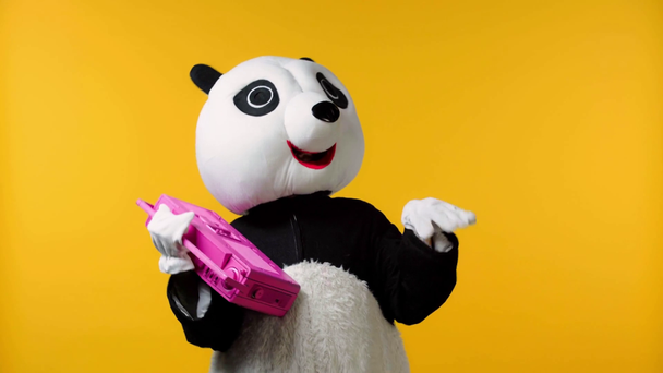 Person im Pandabären-Kostüm tanzt mit Boombox isoliert auf gelb  - Filmmaterial, Video