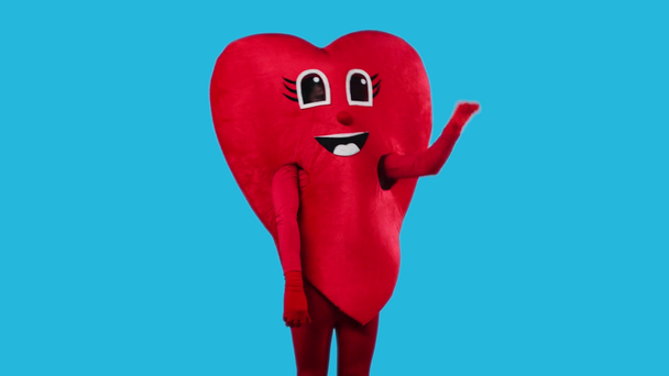person in heart costume showing thumbs down isolated on blue - Footage, Video