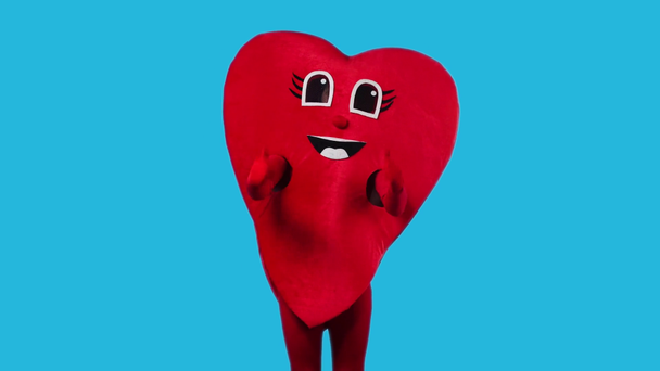 person in heart costume showing thumbs up isolated on blue - Footage, Video