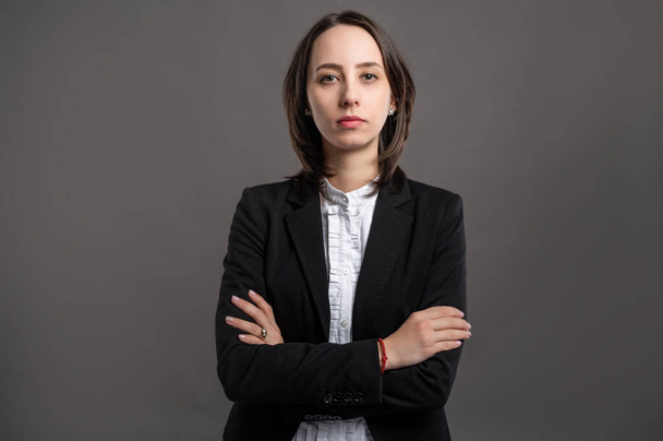 Portrait of wonderful young business woman wering black suit and shirt looking confident poseing on isolated gray background - Photo, Image
