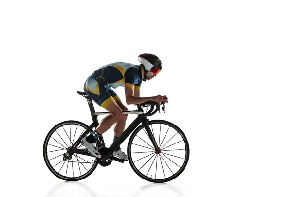 Triathlon male athlete cycle training isolated on white studio background - Foto, Bild