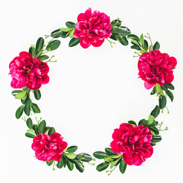 Florale Rahmenkomposition aus roten Pfingstrosen mit Blüten und Blättern auf weißem Hintergrund. Flache Lage - Foto, Bild