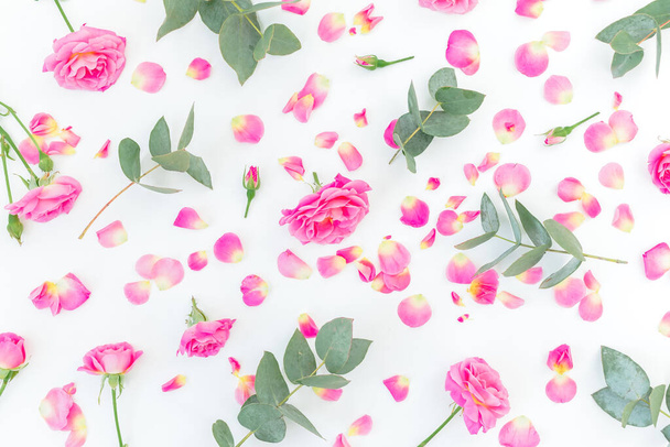 Blumenmuster mit rosa Rosen und Eukalyptus auf weißem Hintergrund. Flache Lage, Draufsicht. - Foto, Bild