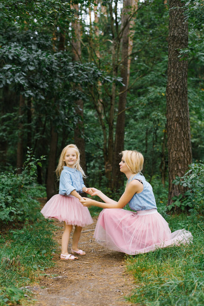 A mother and a five-year-old daughter in the same romantic clothes are walking in the Park or in the woods.They talk and talk about something. Mother's day - Fotografie, Obrázek
