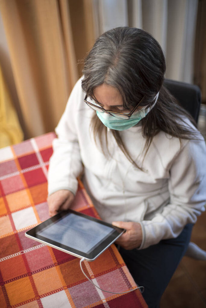 コロナウイルスだ。錠剤とコロナウイルスの病気の女性は、自宅での病気からの安全呼吸保護と回復を身に着けています。感染を防ぐために隔離された患者 - 写真・画像