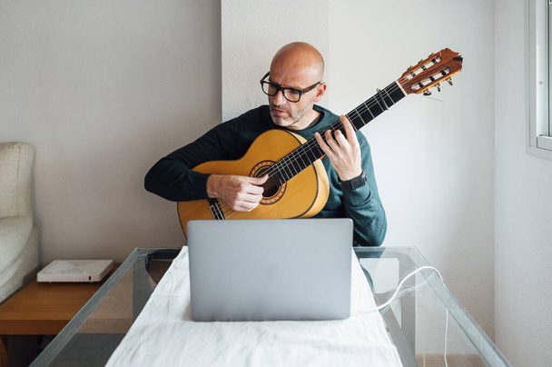 Man learning to play guitar online - Zdjęcie, obraz