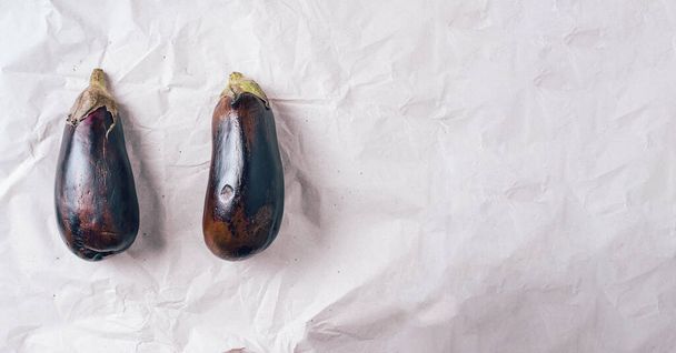 Rotten eggplant on craft paper background. Concept of zero waste production. Top view. Copy space. Non gmo vegetables - Foto, imagen