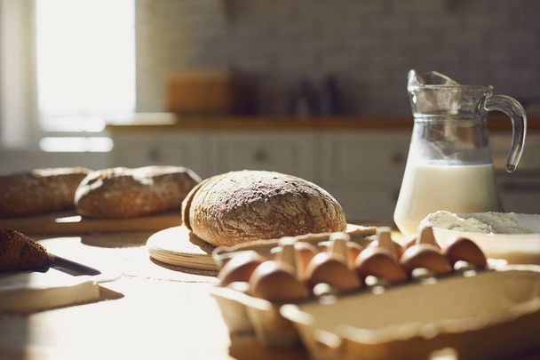 Bakery baker bread. Fresh homemade bread on a table in the kitchen. - 写真・画像
