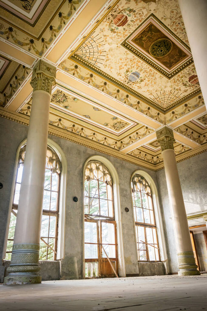 Elhagyott egykori szanatórium Shakhtar csarnok fapadlóval, gyönyörű tömítésekkel és nagy ablakokkal. Gyönyörű szovjet stílusú szobák belső részletek. Tskaltubo.Georgia.2020 - Fotó, kép