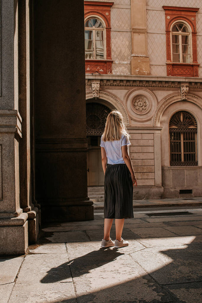 A beautiful woman with blond hair walks through the streets of the city. Girl enjoy holidays in Europe. Beautiful historical architecture. Italian weekend. Travel to Turin, Italy. Adventure lifestyle - Foto, Imagen