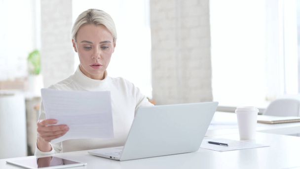 Амбітна молода бізнес-леді використовує документ на ноутбуці
 - Фото, зображення
