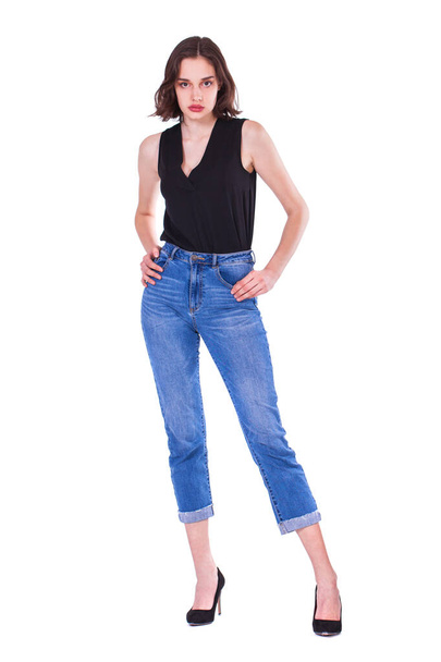 Full body portrait of a young beautiful brunette model in blue jeans, isolated on white background - Fotó, kép