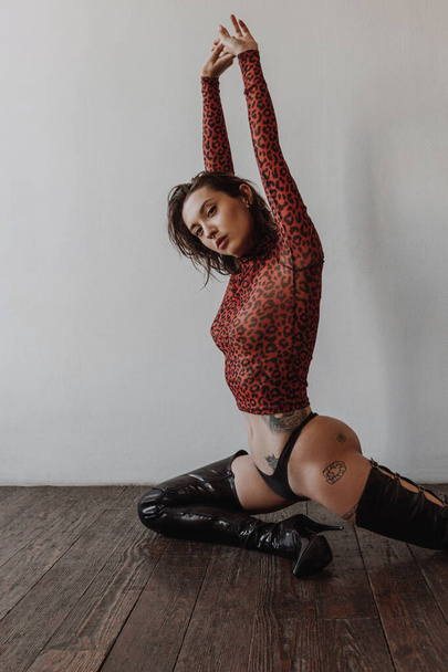 Sexy woman with tattoos wearing black bikini and over the knees boots - 写真・画像