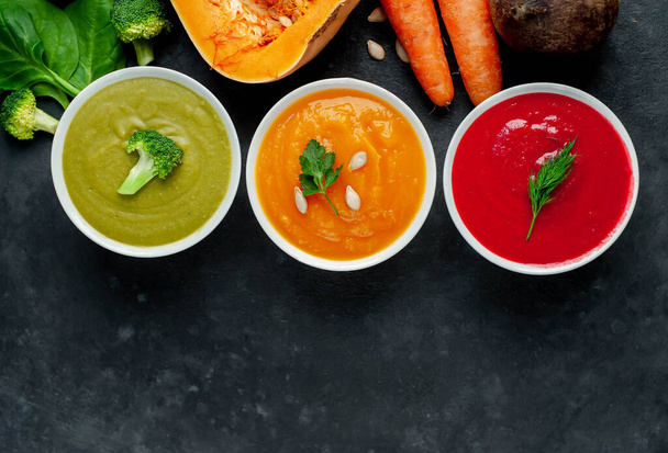 zuppe di panna fresca vegetariana ciotole di zucca, carote e broccoli su fondo tavola rustico
 - Foto, immagini