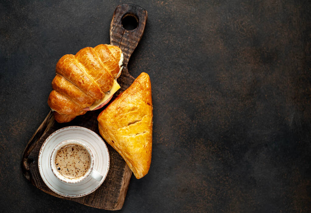 aroma fekete kávé csésze szendvics és croissant szalonna és sajt fa fórumon rusztikus asztal háttér  - Fotó, kép