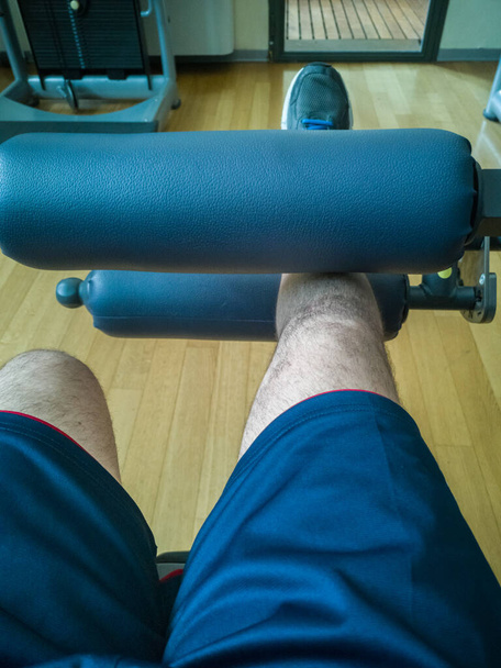 Faire des exercices au gymnase : Entraînement d'extension de jambe sur la machine de fitness, vue en vedette
. - Photo, image