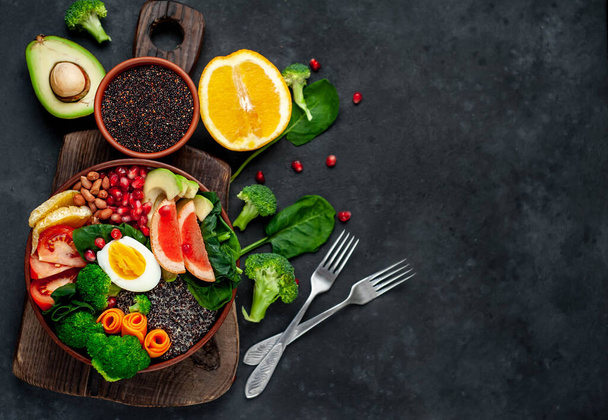 kom met smakelijk vers sap groenten en groenten met fruit en granen op houten plank op rustieke tafel achtergrond - Foto, afbeelding