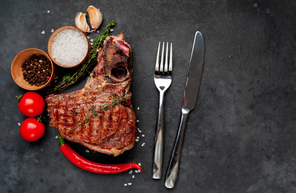 Marinated herb butter T Bone steak with tomatoes on rustic table background - Photo, Image