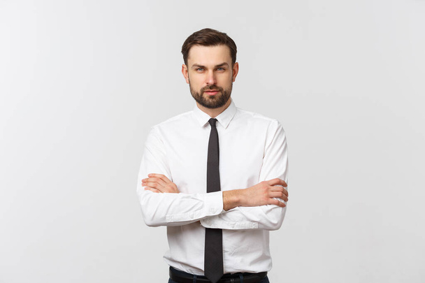 Portrait of a confident young businessman with crossing arms on white background - Photo, Image