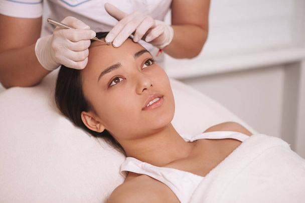 Attraente giovane donna asiatica con procedura di rimozione blackhead presso il salone di cosmetologia, copiare spazio
 - Foto, immagini