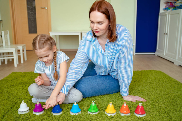 mom and daughter playing colourful musical bells - Photo, Image