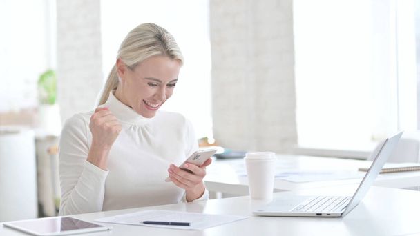 Geschäftsfrau nutzt Smartphone und reagiert auf Erfolg - Foto, Bild