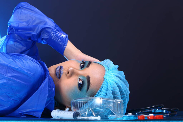 Creative Plastic Surgery on Blue Tone Fashion Patient Female model with medical equipment tools, studio lighting copy space - Фото, изображение