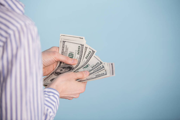  money in a hand over blue background - Foto, Imagem