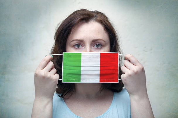 Портрет жінки в масці на сірому фоні. Епідемія коронавірусу в Італії. - Фото, зображення