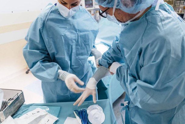 Chirurgo che controlla indossare guanti prima dell'operazione
 - Foto, immagini