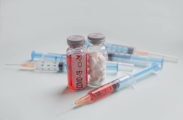 тест с короновирусом С в пробирке и шприце с анализом крови и таблетками в лаборатории
 - Фото, изображение