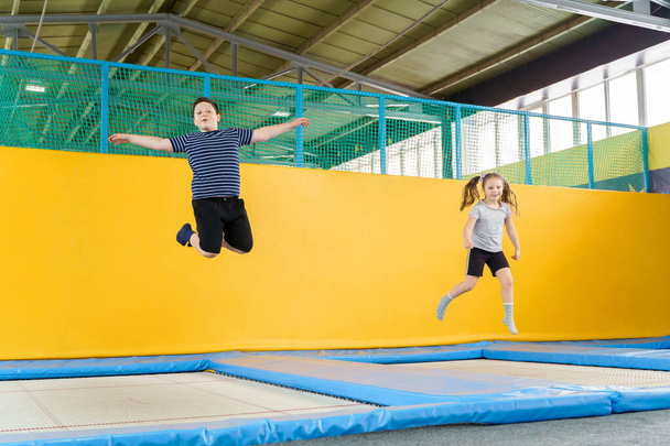 Felice sorridente bambini piccoli che saltano sul trampolino al coperto nel centro di intrattenimento
 - Foto, immagini