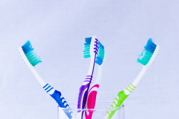 Toothbrushes of different colors in a base and white background - Photo, Image