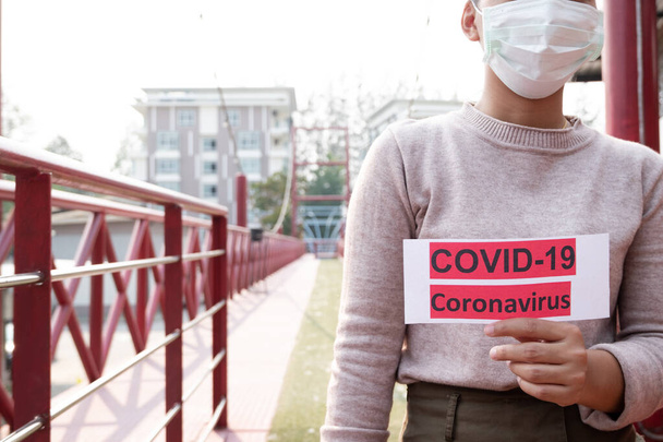 Nuori nainen yllään suojaava kasvonaamio Virusinfektion ehkäisemiseksi epidemiat covid-19 ja PM 2.5
. - Valokuva, kuva
