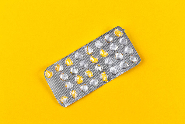 Used blister pack from tablets medicine on yellow background. Medical blister pack opened and empty without pills top view. Medical and healthcare concept. - Foto, Bild