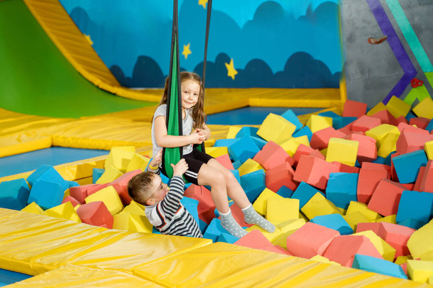 Children playing with soft cubes in the dry pool in play center. playground with foam blocks in trampoline club - Foto, imagen