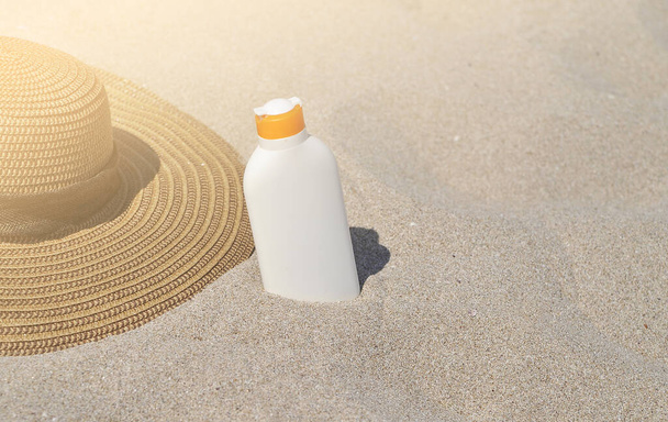 Hat and sun cream protection on sand, Summer time concept. - Fotoğraf, Görsel