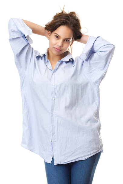 Jovem mulher em jeans azuis e camisa com as mãos no cabelo
 - Foto, Imagem