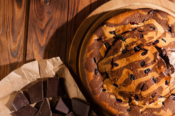 Torta rustica al cioccolato cosparsa di zucchero a velo. Torta al cioccolato su un tavolo di legno
. - Foto, immagini