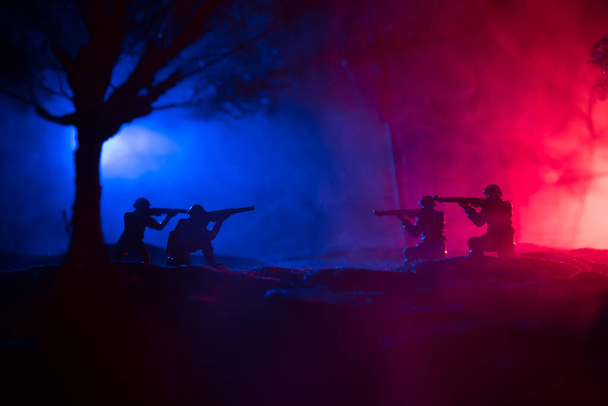 War Concept. Military silhouettes fighting scene on war fog sky background, World War Soldiers Silhouette Below Cloudy Skyline At night. Battle in ruined city. Selective focus - Photo, Image