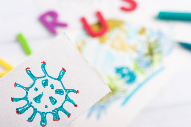 Детский рисунок коронавируса вблизи земли на заднем плане. Концепция защиты от вирусов и борьбы с ними
 - Фото, изображение