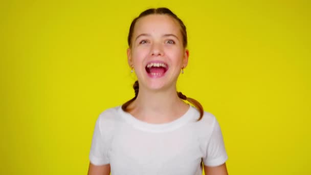 Ένα έφηβο κορίτσι με λευκό μπλουζάκι γελάει και ουρλιάζει.. - Πλάνα, βίντεο