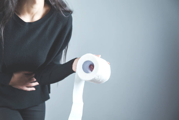 sad woman hand in ache belly with hand  toilet paper - Photo, image