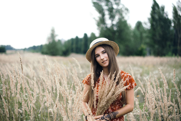Girl in a red dress on a wheat field - Фото, изображение
