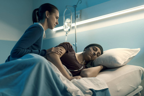Caring woman assisting her sick friend with cancer at the hospital, she is comforting her - Φωτογραφία, εικόνα